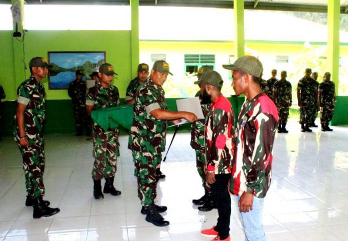 Dandim menyerahkan penghargaan kepada dua pemuda yang menyerahkan senjata kepada Kodim sebagai bentuk kepercayaan.