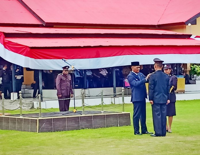 Bupati selaku Inspektur Upacara HUT Polri saat menyematkan tanda penghargaan Bintang Bhayangkara Nararya kepada perwakilan anggota Polres Kaimana.