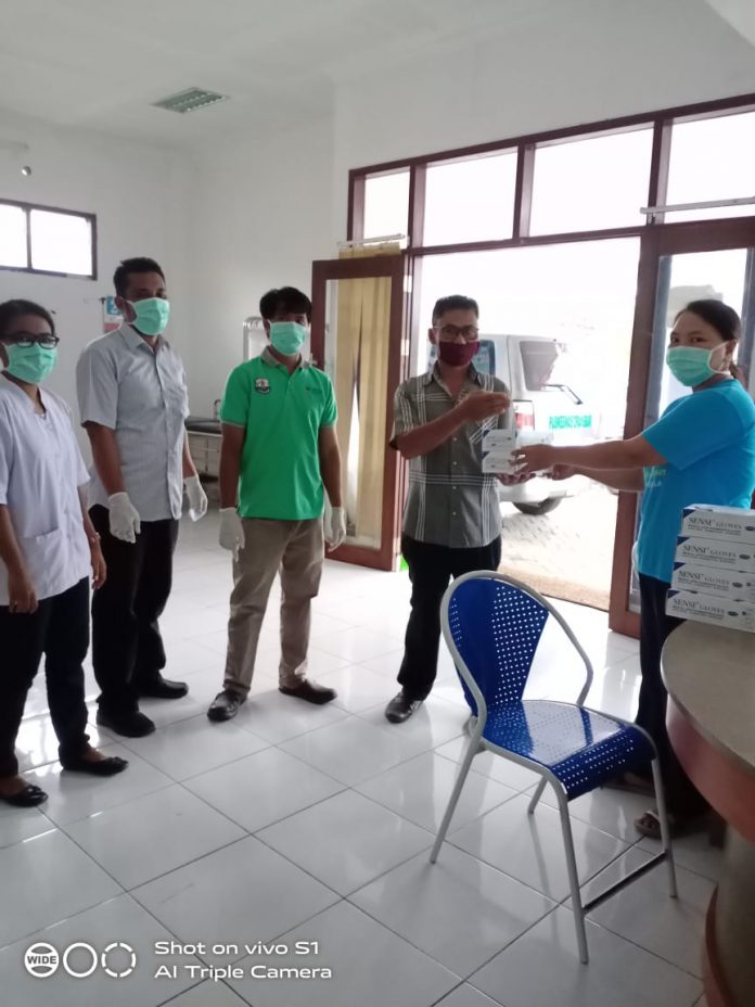 Penyerahkan bantuan sarung tangan medis di Puskesmas Orasbari yang dikirim via jasa pengiriman dari salah seorang mahasiswi asal Oransbari, yang tengah menimbah di Lamongan