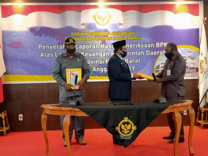 Kepala BPK-RI Perwakilan Papua Barat Arjuna Sakir menyerahkan hasil pemeriksaan kepada Bupati Manokwari Selatan Markus Waran di aula auditorium BPK RI perwakilan Papua Barat, Selasa